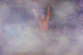 Male break-dancer jumps off high in the air while performing a cool dance move, a lot of smoke in the background Royalty Free Stock Photo