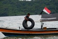 A male bringing rubber tire on a leaning boat