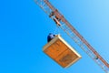 Male in bucket of Tower crane. building construction site. blue sky background Royalty Free Stock Photo