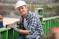 male builder on construction site using spirit level Royalty Free Stock Photo