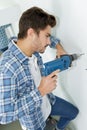 Male builder drilling holes in wall at construction site Royalty Free Stock Photo