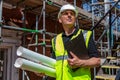 Male Builder Foreman Architect on Building Site With Clipboard and Plans Royalty Free Stock Photo