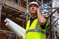 Male Builder Foreman Architect on Building Site Using Phone and Royalty Free Stock Photo