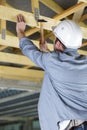 male builder hammers nail into wooden structure