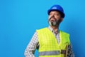 Male builder or handyman in uniform holding clipboard against blue background Royalty Free Stock Photo