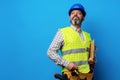 Male builder or handyman in uniform holding clipboard against blue background Royalty Free Stock Photo