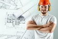 Male builder in a helmet on the background of construction drawings. The concept of construction, architecture, design. Mixed