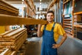 Male builder holds wooden boards in hardware store Royalty Free Stock Photo