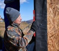 Male builder installing waterproof membrane on wall of future wooden frame house. Royalty Free Stock Photo