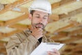 male builder looking at clipboard