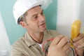 male builder measuring voltage in electrical wall recepticle Royalty Free Stock Photo