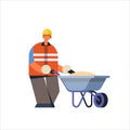 Male builder pushing wheelbarrow with sand busy workman in protective uniform and helmet industrial construction worker