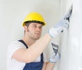 Male builder repairs wall