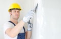 Male builder repairs wall