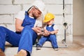 Man showing tool to child in apartment under renovation. Royalty Free Stock Photo