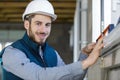 male builder using spirit level to check window Royalty Free Stock Photo