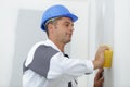 Male builder using sponge on plastered wall Royalty Free Stock Photo