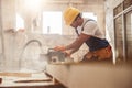 Male builder using wood cutting circular saw machine in workshop Royalty Free Stock Photo