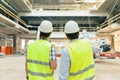 Male building workers working at construction site, back view. Building, development, teamwork and people concept Royalty Free Stock Photo