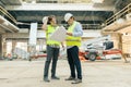 Male building workers working at construction site, builders looking in blueprint. Building, development, teamwork and people Royalty Free Stock Photo