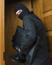 Male burglar in mask stealing monitor Royalty Free Stock Photo