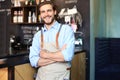 Male business owner behind the counter of a coffee shop with crossed arms, looking at camera Royalty Free Stock Photo