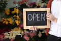 Male business owner holding OPEN sign in his flower shop, closeup Royalty Free Stock Photo