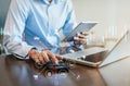 Male businessman or Designer using tablet with laptop and document on desk in modern office with virtual interface graphic icons Royalty Free Stock Photo