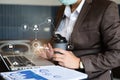 Male businessman using laptop and document on desk in modern office with virtual interface graphic icons network diagram Royalty Free Stock Photo