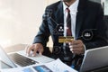 Male businessmen use credit cards to conduct financial transactions through phones tablet and laptop at home office in the