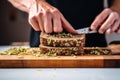 male buttering sprouted grain bread slice