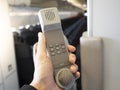 Male cabin crew holding interphone in aircraft cabin. Royalty Free Stock Photo