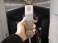 Male cabin crew holding interphone in aircraft cabin. Royalty Free Stock Photo