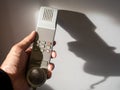 Male cabin crew holding interphone in aircraft cabin.