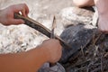 Male camper kindling to start a campfire, bonfire close-up. Man kindles a fire. Fire in nature. Bonfire in the forest. Royalty Free Stock Photo