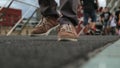 Male in canvas sneakers walking along bridge, trying its firmness by tiny jumps