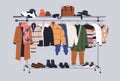 Male capsule wardrobe on racks. Men fashion clothes and accessories on hanger rail. Fall, winter garments, footwear and