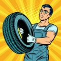 Male car mechanic with wheel