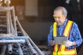Male carpenter in a construction workshop, using a digital tablet Royalty Free Stock Photo