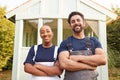 Male Carpenter With Female Apprentice Standing In Front Of Finished Outdoor Summerhouse In Garden Royalty Free Stock Photo