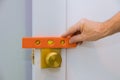 Male carpenter fixing lock in door with home