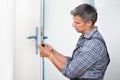 Carpenter Fixing Lock In Door With Screwdriver Royalty Free Stock Photo