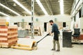 Male carpenter loading a pallet jack with wood boards Royalty Free Stock Photo