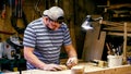 Male carpenter marking figure lines for milling on a wooden detail