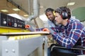 male carpenter training apprentice to use plane