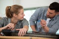 male carpenter training female apprentice to use plane Royalty Free Stock Photo