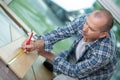 male carpenter working with wood pencil at site Royalty Free Stock Photo