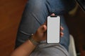 Male in casual looks sitting and holding smartphone mockup