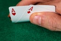 A male caucasian hand Showing a Pair of Aces in the hole, Hearts and Diamonds, a standard red and white deck of cards on a Royalty Free Stock Photo