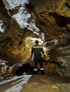 Male caver explores a cave with a flashlight